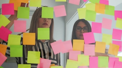 Women brainstorming in office with sticky notes
