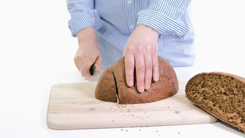 Hands Slice Fresh Brown Bread Loaf