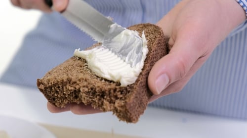 Spreading Creamy Cheese on Dark Bread Slice