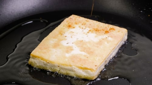 Tofu Block Cooking in Pan Being Seasoned