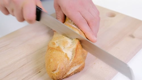 Slicing Fresh Crusty Bread on Cutting Board
