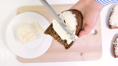 Spreading Butter on Dark Bread Slice
