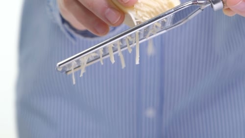 Hand Grating Yellow Cheese with a Metal Grater