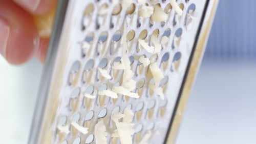 Shredding Cheese with a Metal Grater Close Up
