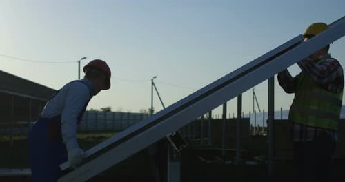 Drei Arbeiter installieren ein Solarpanel
