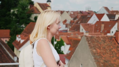 A Female Tourist Admires the Roofs of the Old Eupropean City. Tourism in Europe
