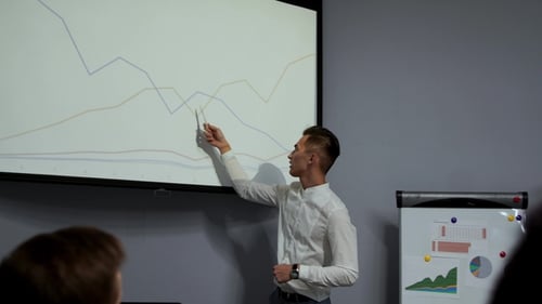 Professional Presenter Discussing Business Data in Conference Room