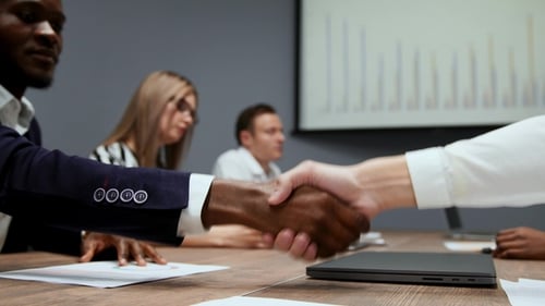 Close - Up of African American Businessman in Suit Shaking Hands with European Businessman
