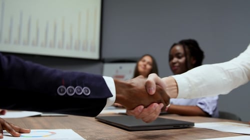 Business Handshake and Celebratory Applause at Office Meeting