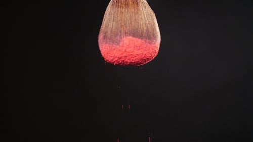 Puderbrush auf schwarzem Hintergrund mit rosa Puder