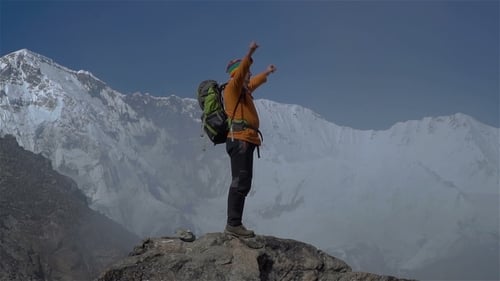 Hiker Reaches Mountain Peak on Sunny Day