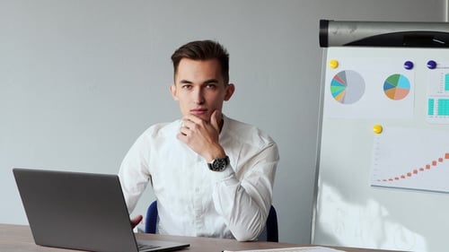 European Male Sitting at a Laptop in the Office with a White Shirt