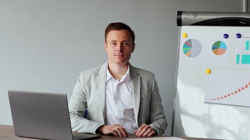 European Male Sitting at a Laptop in the Office with a White Shirt