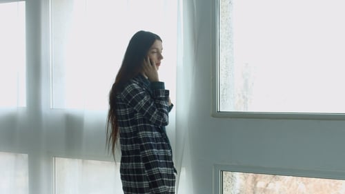 Young Woman Talking on Cell Phone Indoors