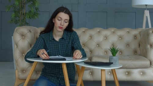 Frustrated Woman with Expense Receipts at Home
