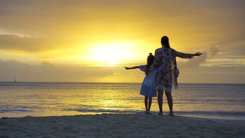 Little Girl and Happy Mother Silhouette in the Sunset at the Beach
