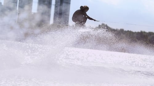 Hombre montando Wake Board a alta velocidad en el río de verano