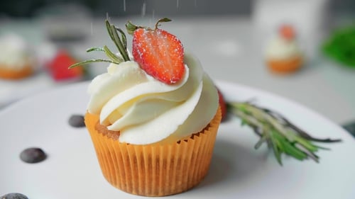 Delicious Cupcake with Strawberry and Rosemary Being Powdered
