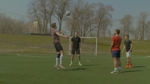 Soccer Players Training Football in the Pitch