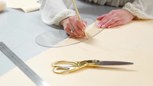 Female Fashion Designer Drawing Sketches for Clothes in Atelier