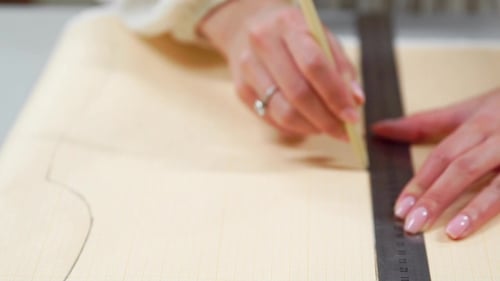 Female Fashion Designer Drawing Sketches for Clothes in Atelier