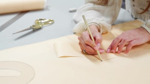 Female Fashion Designer Drawing Sketches for Clothes in Atelier