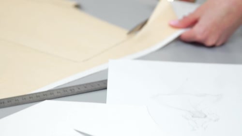 Young Female Designer with Tape-line on Her Neck Standing in Dressmaking Studio