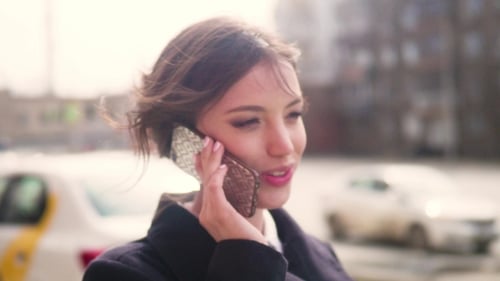 Woman Talking on Smartphone in City Street