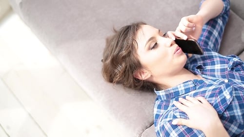 Woman Lying on Sofa Talking on Phone