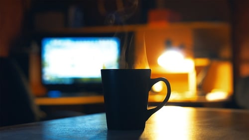 Steaming Drink on Desk with Computer in Background