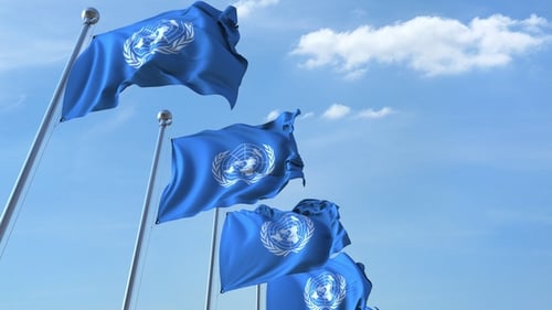 Waving United Nations Flags against Clear Blue Sky