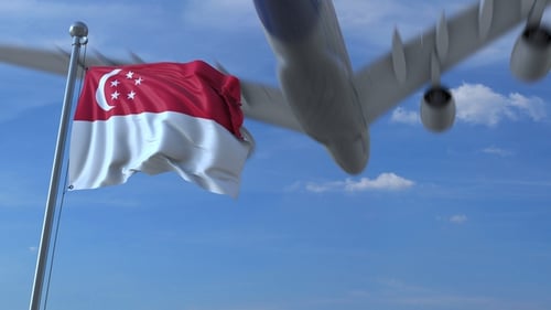 Singapore Flag Waving with Airplane Flying Against Blue Sky