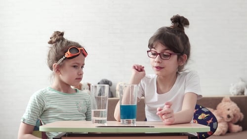 Two Girls Conducting Science Experiment Mixing Liquids