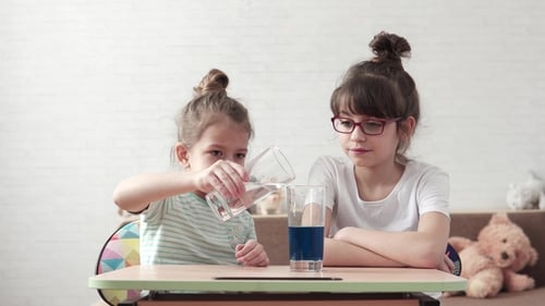 Girls Pouring Water in Science Experiment at Home