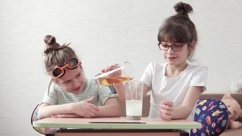 Excited Girls Mixing Liquids in a Science Experiment