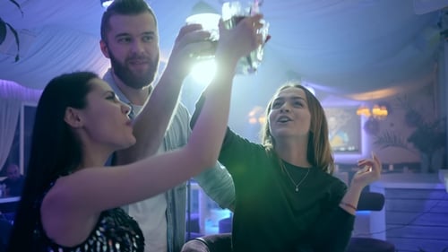 Friends Toasting Drinks at Nighttime Bar Gathering