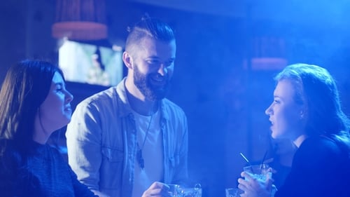 Friends Enjoying Cocktails at Vibrant Nightclub