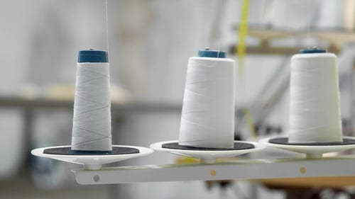 Three Big Bobbins with Thin White Thread on Working Professional Sewing Machine