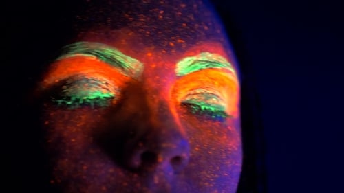 Fashion Sexy Disco Girl Dancing with Shut Eyes in Neon Light. Fluorescent Makeup Glowing Under
