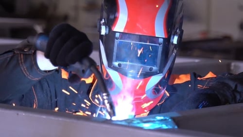 Welder Working With Bright Sparks in Factory
