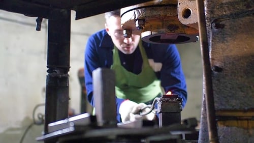 Blacksmith Forging Hot Metal with Automated Press