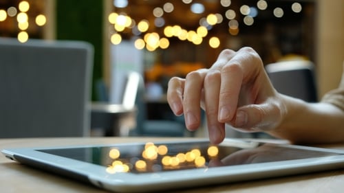 Frau benutzt einen Tablet-Computer-PC in einem Café auf verschwommenem Hintergrund.