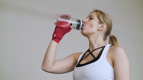 Woman Drinks Water During Workout