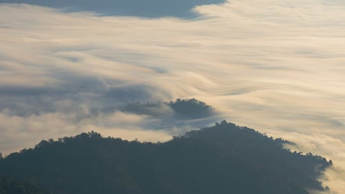 Clouds Float Over Mountain Landscape at Sunset