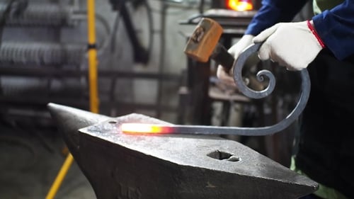 Blacksmith Shaping Hot Metal on Anvil with Hammer