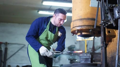 Metalworker Forging Steel with a Machine Press