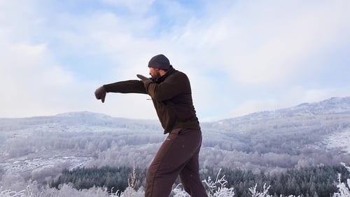 A Boxer Trains in the Mountains in the Fresh Air. He Works Blows Through the Air. A Fight with a
