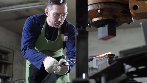 Craftsman Using Forging Press to Shape Metal