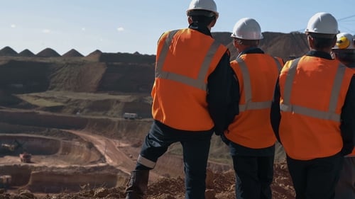 Panorama Shot of a Group of Workers in Overalls Actively Speaking on Board a Bauxite Quarry.
