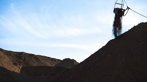Dragline-Bagger lädt Erz. Das Erz wird aus dem Eimer gegossen.